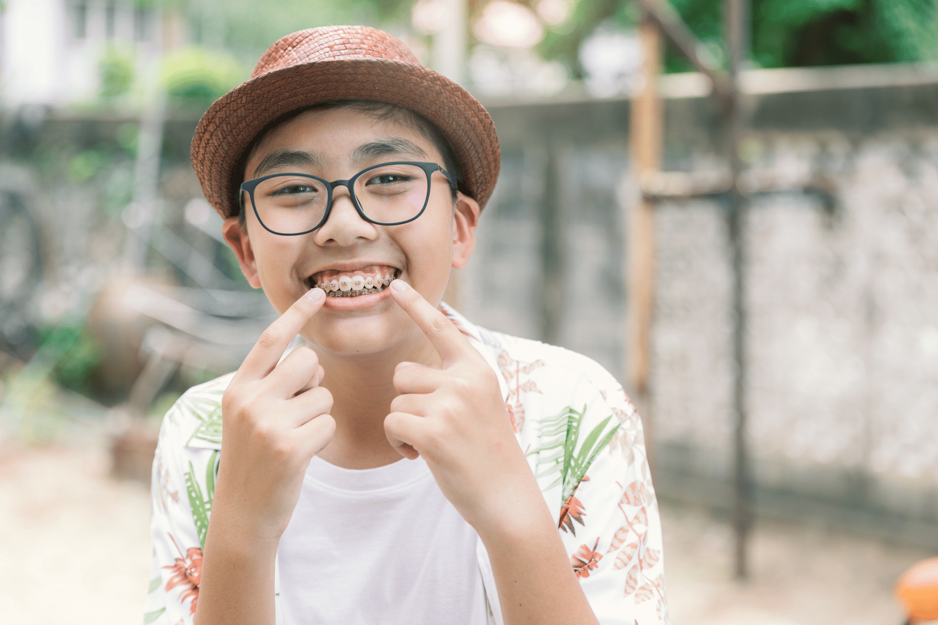Smiling child wearing braces and pointing to their teeth