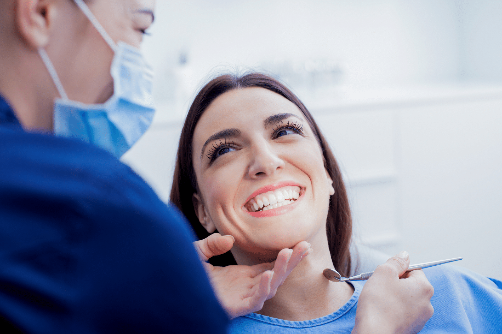A young woman with a wide, happy smile during a comfortable dental examination.